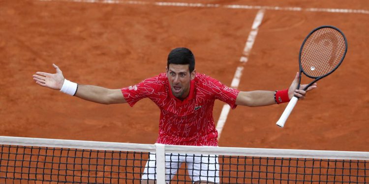 Serbia's Novak Djokovic reacts during a tennis doubles match with Jelena Jankovic against Serbia's Nenad Zimonjic and Olga Danilovic during the Adria Tour charity tournament, in Belgrade, Serbia, Friday, June 12, 2020. Serbian tennis player Novak Djokovic set up a series of tennis tournaments in the Balkan region while the sport is suspended amid the coronavirus pandemic. (AP Photo/Darko Vojinovic)