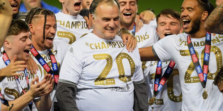 LEEDS, ENGLAND - JULY 22: The players of Leeds celebrate their manager Marcelo Bielsa with the trophy during the Sky Bet Championship match between Leeds United and Charlton Athletic at Elland Road on July 22, 2020 in Leeds, England. Football Stadiums around Europe remain empty due to the Coronavirus Pandemic as Government social distancing laws prohibit fans inside venues resulting in all fixtures being played behind closed doors. (Photo by Michael Regan/Getty Images)