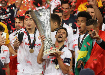 Sevilla's Spanish midfielder Jesus Navas holds the trophy as Sevilla's players celebrate  after winning the UEFA Europa League final football match Sevilla v Inter Milan on August 21, 2020, in Cologne, western Germany. (Photo by Lars Baron / POOL / AFP) (Photo by LARS BARON/POOL/AFP via Getty Images)