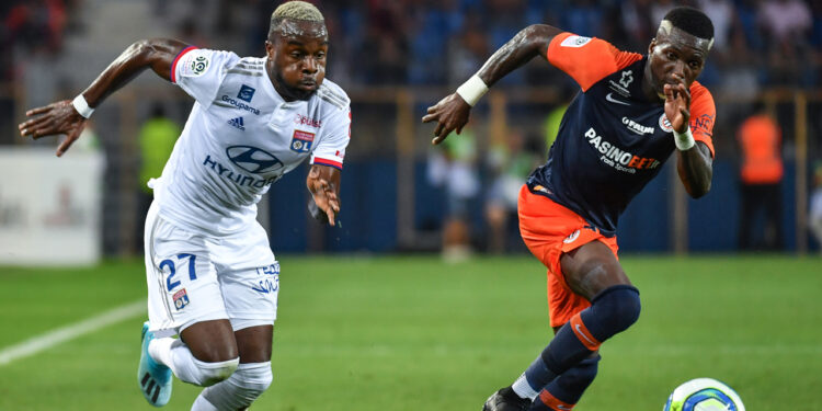 Lyon's Ivorian forward Maxwell Gnaly Cornet (L) vies with Montpellier's Cameroon defender Ambroise Oyongo during the French L1 football match between Montpellier Herault SC and Olympique Lyonnais at the Mosson stadium in Montpellier, southern France, on August 27, 2019. (Photo by PASCAL GUYOT / AFP)