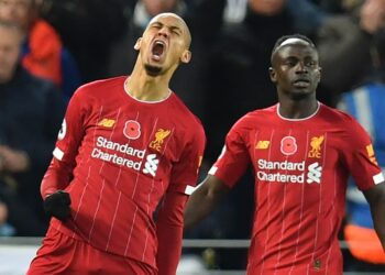 Liverpool's Brazilian midfielder Fabinho (L) celebrates after scoring the opening goal of the English Premier League football match between Liverpool and Manchester City at Anfield in Liverpool, north west England on November 10, 2019. (Photo by Paul ELLIS / AFP) / RESTRICTED TO EDITORIAL USE. No use with unauthorized audio, video, data, fixture lists, club/league logos or 'live' services. Online in-match use limited to 120 images. An additional 40 images may be used in extra time. No video emulation. Social media in-match use limited to 120 images. An additional 40 images may be used in extra time. No use in betting publications, games or single club/league/player publications. /  (Photo by PAUL ELLIS/AFP via Getty Images)