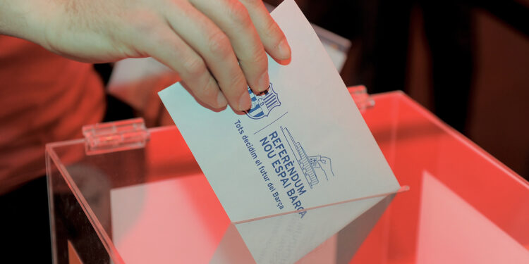 A Barcelona football club partner casts his ballot at the Camp Nou stadium in Barcelona on April 5, 2014 during a referendum by Barcelona FC partners for the renovation of the club's stadium. The polls opened at 0900 local ( 0700 GMT ) and four hours later 11,730 voting members of the118,580 had voted on wheter or not to expand capacity to 105,000 seats and a set roof over the existing structure. AFP PHOTO/ JOSEP LAGO        (Photo credit should read JOSEP LAGO/AFP via Getty Images)