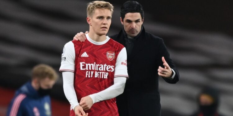 Arsenal's Norwegian midfielder Martin Odegaard (L) gets instructions from Arsenal's Spanish manager Mikel Arteta (R) as he comes on as a substitute during the English Premier League football match between Arsenal and Manchester United at the Emirates Stadium in London on January 30, 2021. (Photo by Shaun Botterill / POOL / AFP) / RESTRICTED TO EDITORIAL USE. No use with unauthorized audio, video, data, fixture lists, club/league logos or 'live' services. Online in-match use limited to 120 images. An additional 40 images may be used in extra time. No video emulation. Social media in-match use limited to 120 images. An additional 40 images may be used in extra time. No use in betting publications, games or single club/league/player publications. /  (Photo by SHAUN BOTTERILL/POOL/AFP via Getty Images)
