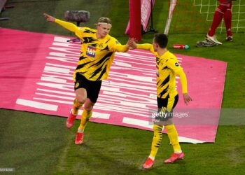 MUNICH, GERMANY - MARCH 06: Erling Haaland of Borussia Dortmund  celebrates with teammate Thorgan Hazard  after scoring their team's second goal  during the Bundesliga match between FC Bayern Muenchen and Borussia Dortmund at Allianz Arena on March 06, 2021 in Munich, Germany. Sporting stadiums around Germany remain under strict restrictions due to the Coronavirus Pandemic as Government social distancing laws prohibit fans inside venues resulting in games being played behind closed doors. (Photo by Günter Schiffmann - Pool/Getty Images)