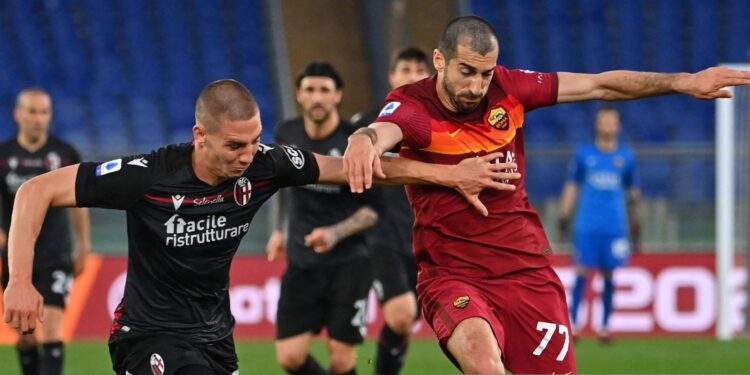 Bologna's Bulgarian defender Valentin Antov (L) and Roma's Armenian midfielder Henrikh Mkhitaryan go for the ball during the Italian Serie A football match AS Rome vs Bologna on April 11, 2021 at the Olympic stadium in Rome. (Photo by ANDREAS SOLARO / AFP) (Photo by ANDREAS SOLARO/AFP via Getty Images)