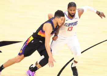 Jan 3, 2021; Phoenix, Arizona, USA; Phoenix Suns guard Devin Booker (1) dribbles against Los Angeles Clippers guard Paul George (13) in the second half at Phoenix Suns Arena. Mandatory Credit: Billy Hardiman-USA TODAY Sports