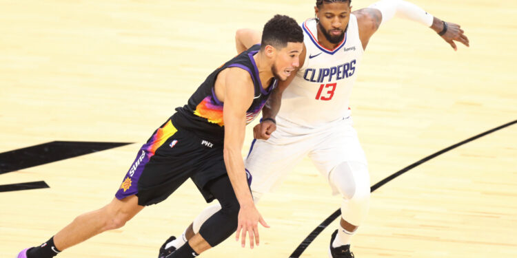 Jan 3, 2021; Phoenix, Arizona, USA; Phoenix Suns guard Devin Booker (1) dribbles against Los Angeles Clippers guard Paul George (13) in the second half at Phoenix Suns Arena. Mandatory Credit: Billy Hardiman-USA TODAY Sports