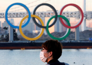 FILE PHOTO: A man wears a protective mask amid the coronavirus (COVID-19) outbreak in front of the giant Olympic rings in Tokyo, Japan, January 13, 2021. REUTERS/Kim Kyung-Hoon//File Photo