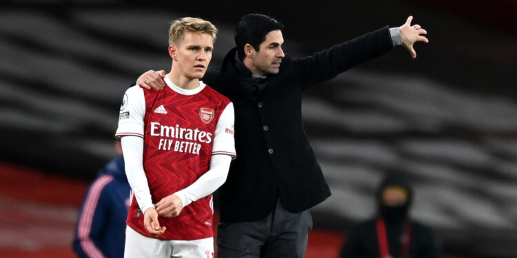 LONDON, ENGLAND - JANUARY 30: Mikel Arteta, Manager of Arsenal gives Martin Odegaard of Arsenal instructions before coming on for his debut during the Premier League match between Arsenal and Manchester United at Emirates Stadium on January 30, 2021 in London, England. Sporting stadiums around the UK remain under strict restrictions due to the Coronavirus Pandemic as Government social distancing laws prohibit fans inside venues resulting in games being played behind closed doors. (Photo by Shaun Botterill/Getty Images)