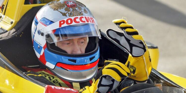 Russian Prime Minister Vladimir Putin wears a helmet and the uniform of the Renault Formula One team before driving a F1 race car on a special track in Leningrad region outside St. Petersburg on November 7, 2010.  AFP PHOTO / RIA NOVOSTI / POOL / ALEXEY DRUZHININ (Photo credit should read ALEXEY DRUZHININ/AFP/Getty Images)