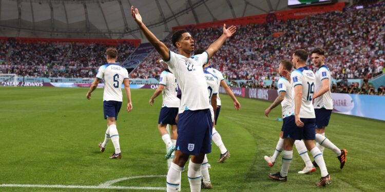 England's midfielder #22 Jude Bellingham (C) celebrates scoring his team's first goal during the Qatar 2022 World Cup Group B football match between England and Iran at the Khalifa International Stadium in Doha on November 21, 2022. (Photo by Adrian DENNIS / AFP) (Photo by ADRIAN DENNIS/AFP via Getty Images)
