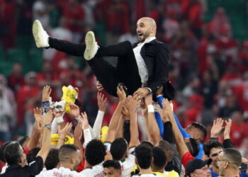 TOPSHOT - Morocco's coach #00 Walid Regragui is thrown into the air as his players celebrate winning the Qatar 2022 World Cup Group F football match between Canada and Morocco at the Al-Thumama Stadium in Doha on December 1, 2022. (Photo by Fadel Senna / AFP)