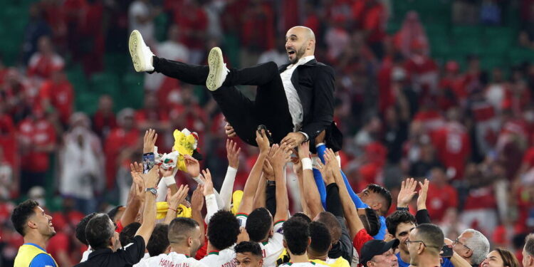 TOPSHOT - Morocco's coach #00 Walid Regragui is thrown into the air as his players celebrate winning the Qatar 2022 World Cup Group F football match between Canada and Morocco at the Al-Thumama Stadium in Doha on December 1, 2022. (Photo by Fadel Senna / AFP)