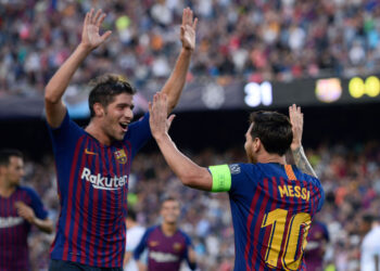 Barcelona's Argentinian forward Lionel Messi (R) celebrates with Barcelona's Spanish midfielder Sergi Roberto after scoring during the UEFA Champions' League group B football match FC Barcelona against PSV Eindhoven at the Camp Nou stadium in Barcelona on September 18, 2018. (Photo by Josep LAGO / AFP)        (Photo credit should read JOSEP LAGO/AFP via Getty Images)
