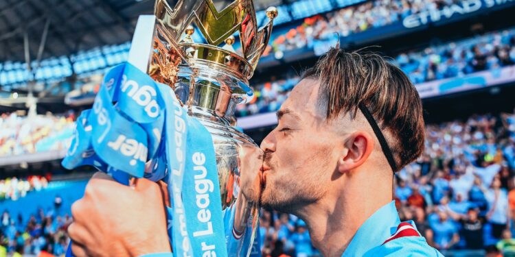 MANCHESTER, ENGLAND - MAY 21: Jack Grealish of Manchester City kisses the Premier League Trophy following the Premier League match between Manchester City and Chelsea FC at Etihad Stadium on May 21, 2023 in Manchester, England. (Photo by Michael Regan/Getty Images)