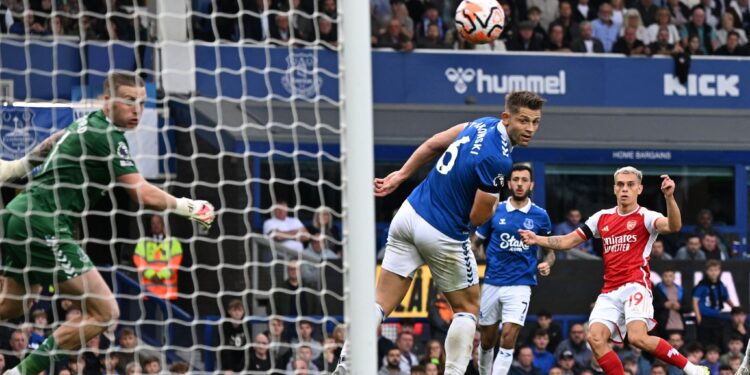Arsenal's Belgian midfielder #19 Leandro Trossard (R) watches as his shot beats Everton's English goalkeeper #01 Jordan Pickford (L) for the opening goal of the English Premier League football match between Everton and Arsenal at Goodison Park in Liverpool, north west England on September 17, 2023. (Photo by Paul ELLIS / AFP) / RESTRICTED TO EDITORIAL USE. No use with unauthorized audio, video, data, fixture lists, club/league logos or 'live' services. Online in-match use limited to 120 images. An additiona