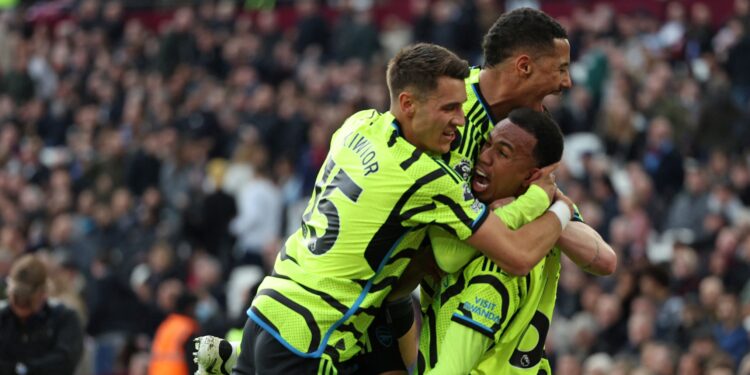 Arsenal's Brazilian defender #06 Gabriel Magalhaes celebrates with teammates after scoring their third goal during the English Premier League football match between West Ham United and Arsenal at the London Stadium, in London on February 11, 2024. (Photo by Adrian DENNIS / AFP) / RESTRICTED TO EDITORIAL USE. No use with unauthorized audio, video, data, fixture lists, club/league logos or 'live' services. Online in-match use limited to 120 images. An additional 40 images may be used in extra time. No video e