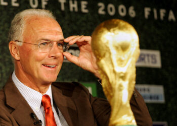 FILE PHOTO: Organising Committee President for the Soccer World Cup 2006 in Germany, Franz Beckenbauer, looks at the trophy during a news conference in Berlin September 16, 2004. REUTERS/Michael Dalder  MAD/JOH/File Photo