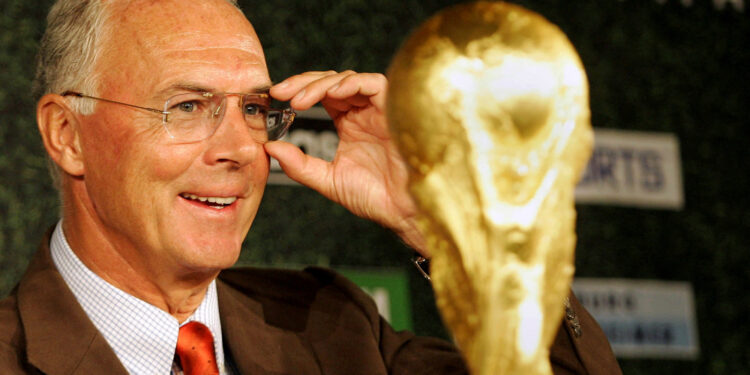 FILE PHOTO: Organising Committee President for the Soccer World Cup 2006 in Germany, Franz Beckenbauer, looks at the trophy during a news conference in Berlin September 16, 2004. REUTERS/Michael Dalder  MAD/JOH/File Photo