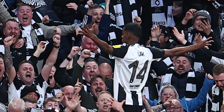 Newcastle United's Swedish striker #14 Alexander Isak (C) celebrates in front of the Newcastle fans after scoring their second goal during the English League Cup final football match between Liverpool and Newcastle United at Wembley Stadium, north-west London on March 16, 2025. (Photo by HENRY NICHOLLS / AFP) / RESTRICTED TO EDITORIAL USE. No use with unauthorized audio, video, data, fixture lists, club/league logos or 'live' services. Online in-match use limited to 120 images. An additional 40 images may b